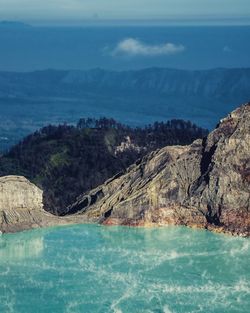 Scenic view of lake by mountains against sky