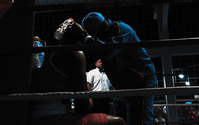 Coach instructing boxer in ring