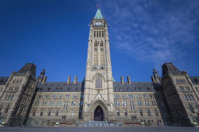 Low angle view of clock tower against blue sky