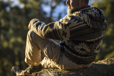 Rear view of man sitting outdoors