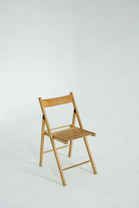 Empty chair on table against white background