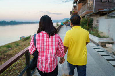 Rear view of couple kissing against the sky