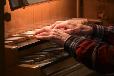 Cropped hand of man playing piano