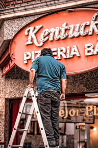 Rear view of man standing against graffiti