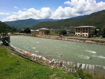 Scenic view of lake by buildings against sky