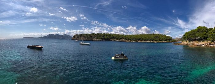 Boats sailing on sea against sky