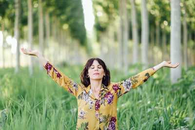 Young woman with arms outstretched standing on land