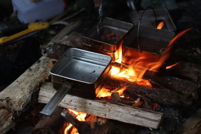 Cooking food in the forest using firewood in a box-shaped frying pan.