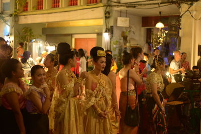 Group of people at illuminated market during night