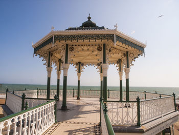 Empty gazebo at brighton pier by sea against clear sky on sunny day