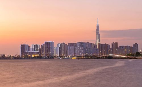 Illuminated buildings in city during sunset