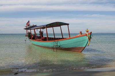 View of a typical cambodian long-tale boat anchored on the beach of otres near sihanoukville