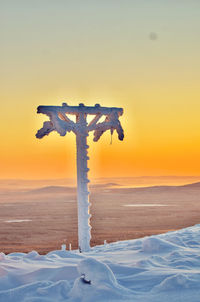 Scenic view of snow covered land during sunset