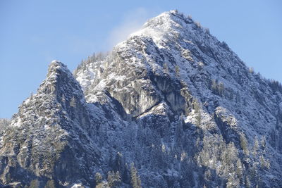 Low angle view of snowcapped mountain against sky