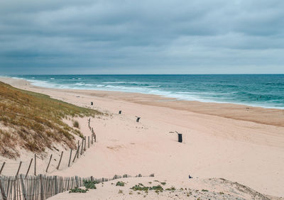 The sandy beach of the landes with the blue ocean and the gray sky