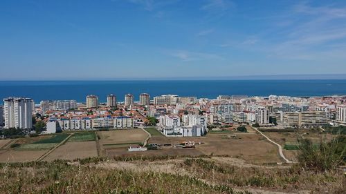 High angle view of buildings by sea against sky