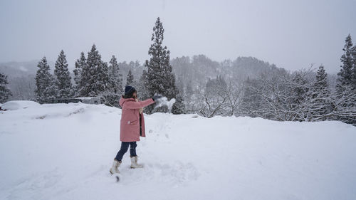 Full length of woman walking on snow covered field