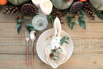 Autumn table decor. table setting with eucalyptus branches, pumpkins, cones and nuts, cotton flowers