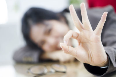 Close-up of woman hand gesturing ok sign at home