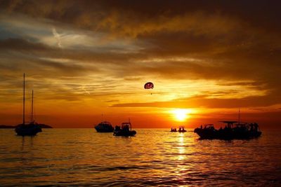 Sailboat sailing in sea at sunset