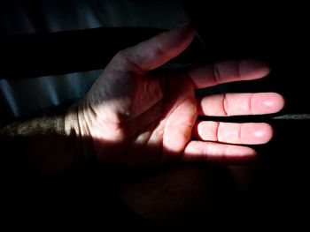 Close-up of baby hand against black background