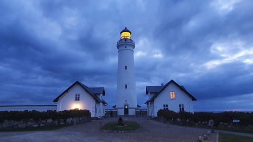 Lighthouse by sea against sky