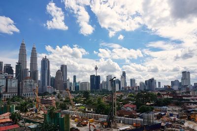 View of cityscape against cloudy sky