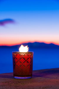 Candle glass at sunset in italy, sea and elba island, in the background