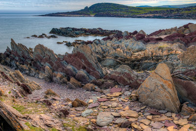 Scenic view of rocks on beach against sky