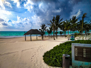 Scenic view of beach against cloudy sky