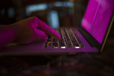 Close-up of hand using keyboard laptop