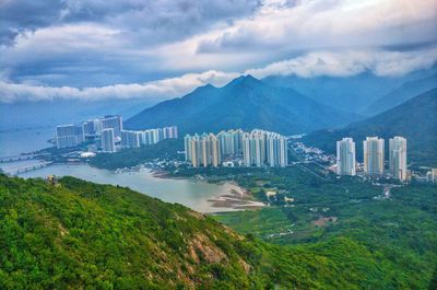 Scenic view of bay and buildings against sky