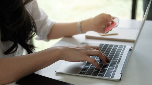 Midsection of woman using mobile phone