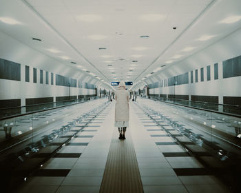 Rear view of woman walking in corridor