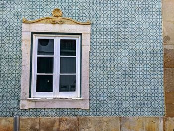 A window on a blue tiled building in lagos, portugal 