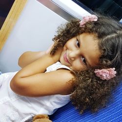 Close-up of smiling girl sitting on sofa at home