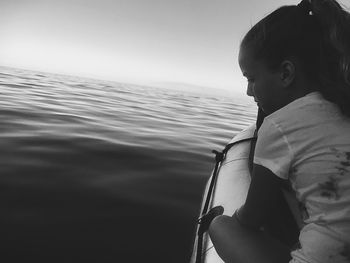 Close-up of child in sea against clear sky