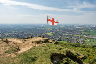 Scenic view of flag amidst buildings against sky