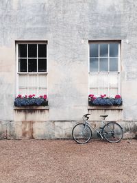 Bicycle parked by windows of building 