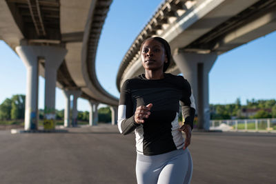 Determined ethnic athlete running in morning