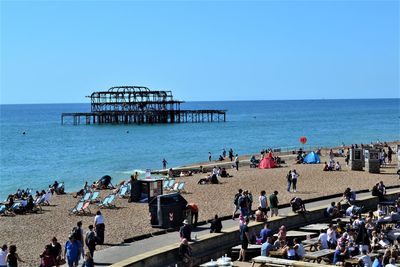 People on beach against clear sky