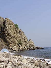 Scenic view of sea and cliff against clear sky