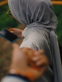 Midsection of woman holding mobile phone