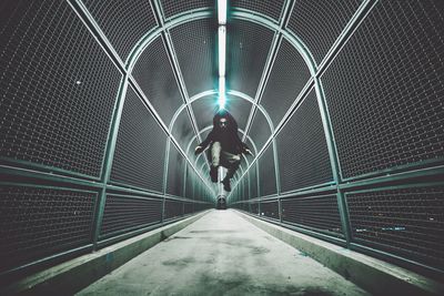 Full length of woman walking in tunnel