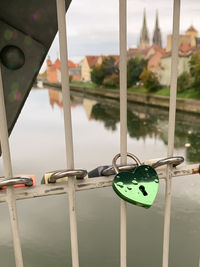 Close-up of padlocks on railing against sky