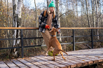 Low angle view of young man with dog on footpath