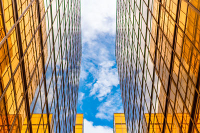 Low angle view of glass building against sky