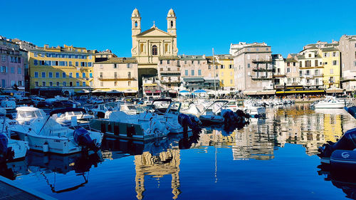 Boats moored against buildings in river