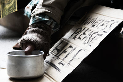 Cropped hand begging with text on cardboard