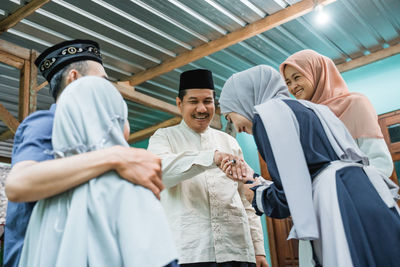 Grandfather giving blessing to girl at home